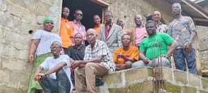 Pastors and church leaders from Liberia posing together on the steps of a concrete building